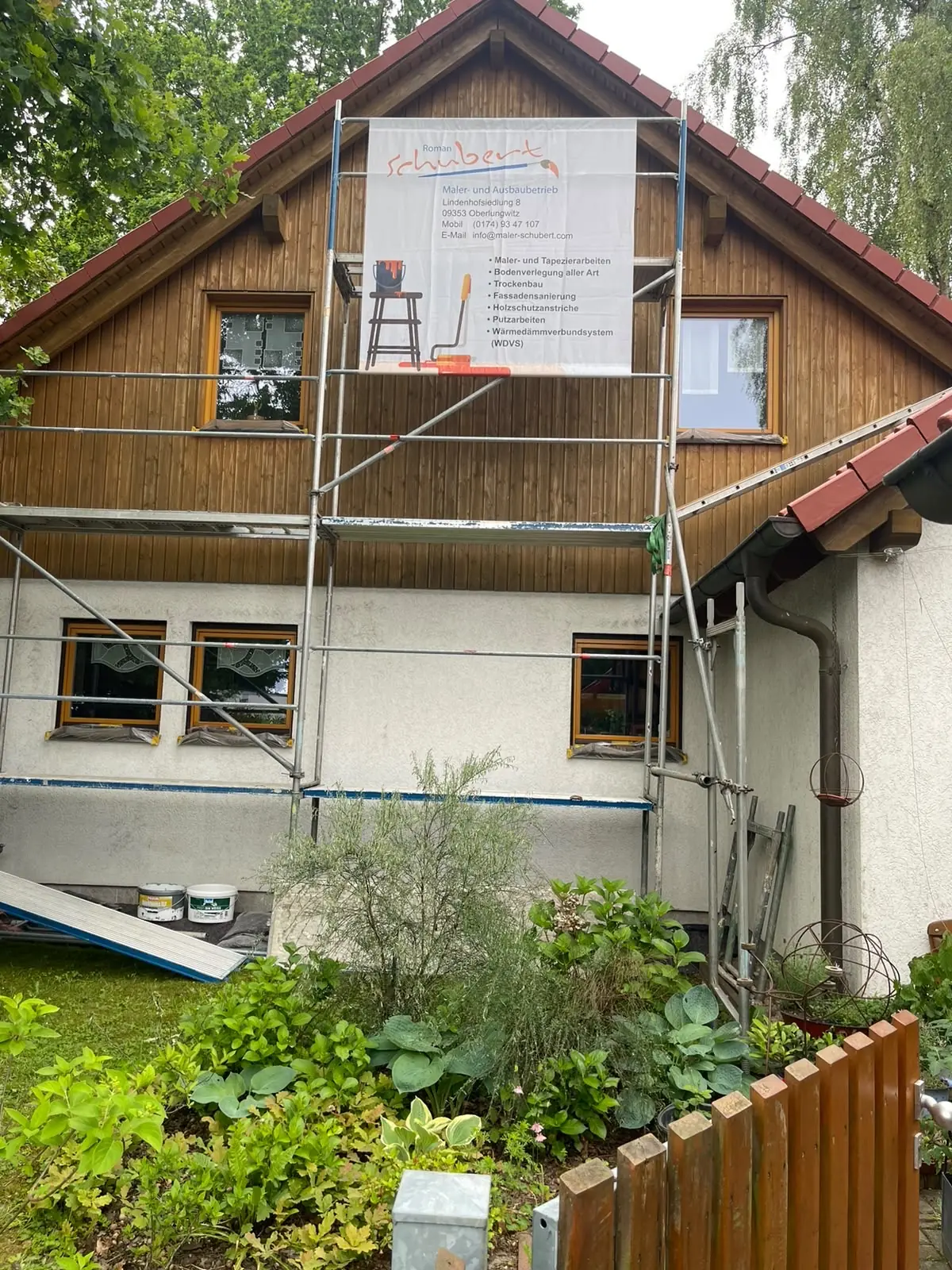 Wohnhaus mit Gerüst und Firmenbanner von Roman Schubert während einer Fassadensanierung